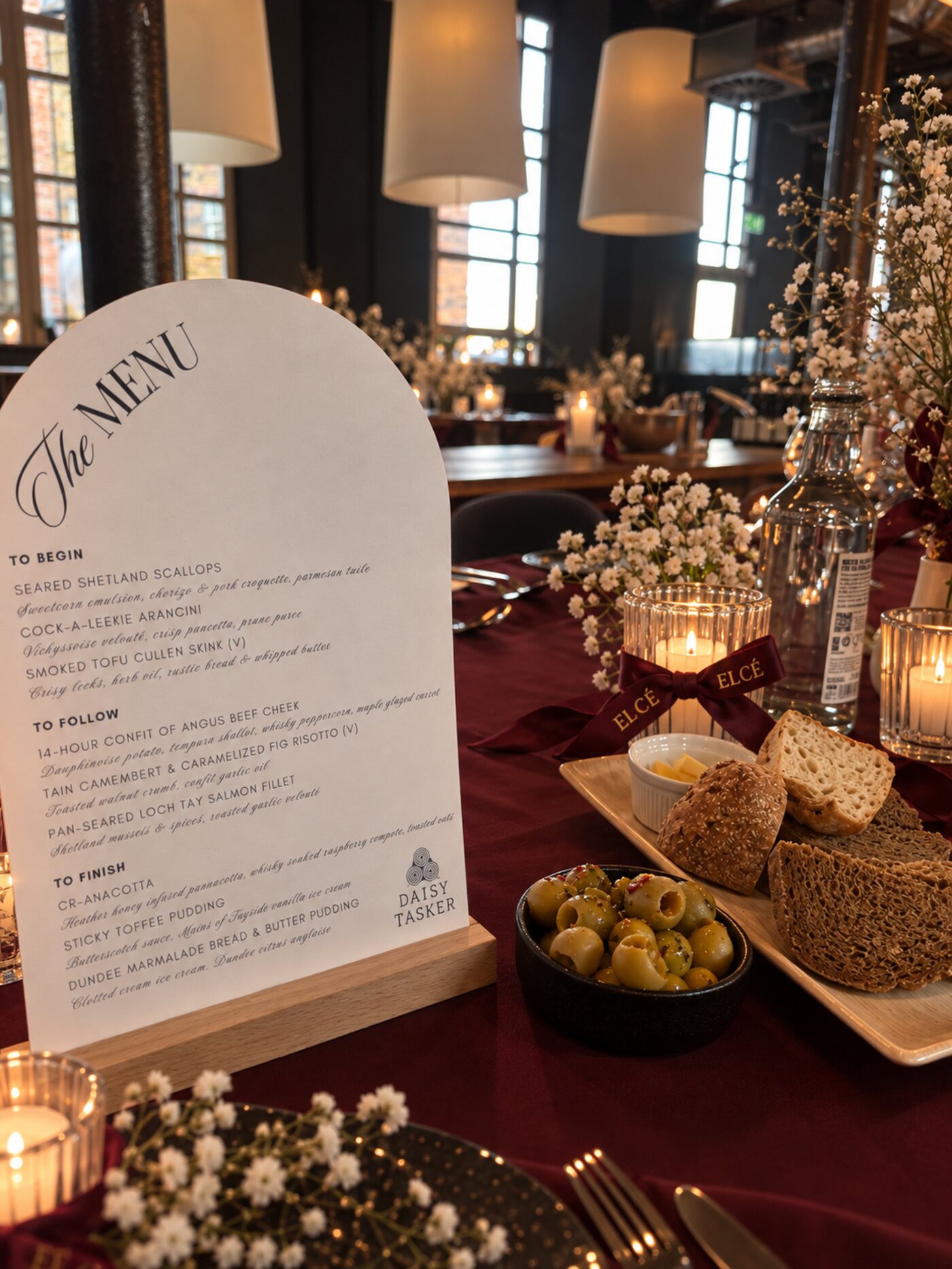 Candlelit burgundy tablescape with arched menu and ELCÉ ribbon